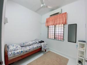 a bedroom with a bed and a window at Grandmaa Homestay, Seberang Takir in Kuala Terengganu