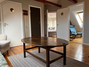 Rooms in the center of Ystad في إيستاد: طاولة خشبية في غرفة مع غرفة معيشة