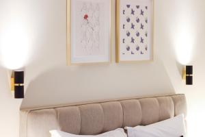een slaapkamer met een bank en twee foto's aan de muur bij HM - Almada City Stay in Porto