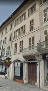 Un grand bâtiment blanc avec balcon se trouve dans une rue. dans l'établissement Hôtel Particulier Morez, à Morez