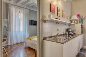 una cocina con fregadero y una cama en una habitación en RomExperience Borgo Pio, en Roma