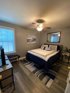 a bedroom with a bed and a ceiling fan at Xscapecation Oasis in Tulsa