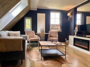 a living room with a couch and a fireplace at country-suites by verdino LIVING - Apartments & Suites in Braunlage