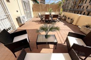 une terrasse avec des tables, des chaises et une table avec une plante dans l'établissement Amazing Flat with Terrace, à Milan