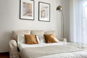un letto con due cuscini sopra in una camera da letto di Amazing Flat with Terrace a Milano