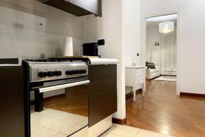 a kitchen with a black and white stove top oven at Amazing Flat with Terrace in Milan