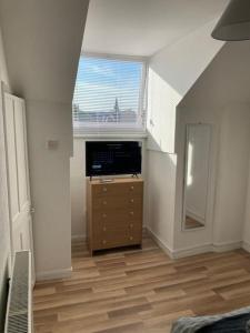 een kamer met een slaapkamer met een dressoir en een raam bij Trent Bridge house in Nottingham