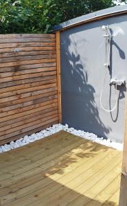 a wooden privacy fence with a shower in a backyard at Le Tilleul in Sciez