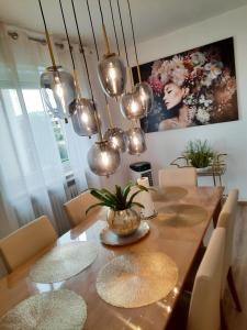 a dining room with a table with chairs and lights at Moderne 3Zimmer Wohnung, in Königsbrunn bei Augsburg in Königsbrunn