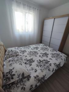 1 cama con edredón blanco y negro y ventana en Dado, en Herceg-Novi