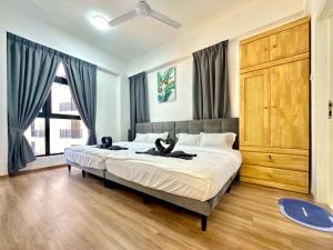 zwei Katzen, die in einem Schlafzimmer auf einem Bett liegen in der Unterkunft Ipoh Cozy Homestay by Comfort Home in Ipoh + 52 Fotos