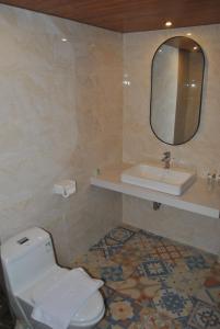 uma casa de banho com um WC, um lavatório e um espelho. em Room in Villa - Love Without boundaries num9759 em Siyut