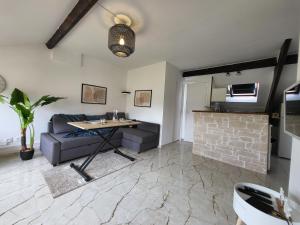 ein Wohnzimmer mit einem Sofa und einem Tisch in der Unterkunft Le Nouvo : bel appartement entièrement rénové in Corbeil-Essonnes