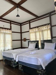 Dewa Daru Resort في كاريمونجاوا: سريرين توأم في غرفة نوم بسقوف خشبية