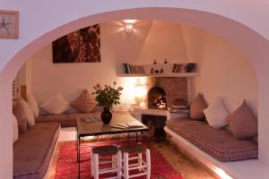 La Casa Del Mar في الصويرة: غرفة معيشة مع أريكة ومدفأة