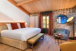 a bedroom with a bed and a chair in a room at LOU CALEN in Cotignac +160 photos