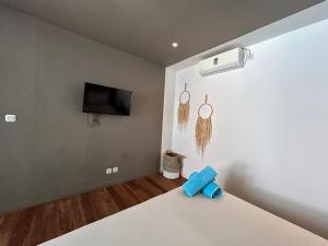 a bedroom with a bed with a tv on the wall at Meno Suites in Gili Meno