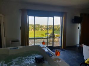 a bath tub with a view of a patio at Le pré en bulles in Lespesses