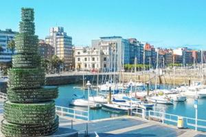 a tall stack of money in a marina with boats at Espectacular piso en la playa in Gijón