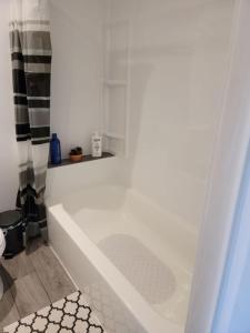 a white bath tub in a bathroom at Comfy 1 bdrm apartment close to highway in Edmundston