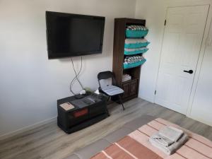 uma sala de estar com uma televisão, uma cadeira e uma mesa em Comfy 1 bdrm apartment close to highway em Edmundston