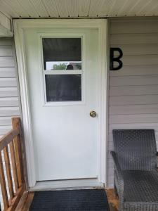 a white door on a house with a window at Comfy 1 bdrm apartment close to highway in Edmundston