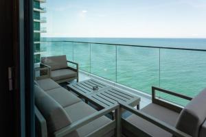 a balcony with a couch and a table and the ocean at Batumi View Luxury in Batumi