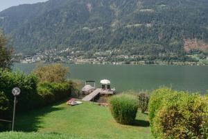 een steiger met een prieel in het midden van een meer bij Seevilla Lotte Ossiachersee in Annenheim