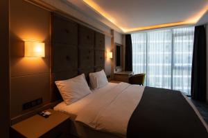 a hotel room with a bed and a large window at Batumi View Luxury in Batumi