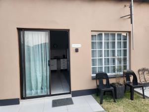 a room with a balcony with two chairs and a table at Sunny Guest Room in Boksburg