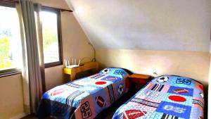2 camas en una habitación con ventana en Casa en Pingueral, en Dichato