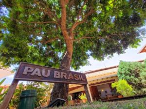 un cartello di fronte a un edificio con un albero di Pousada Galeria Artes a Bonito