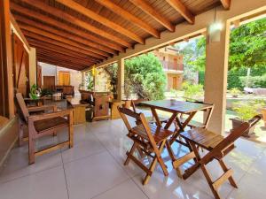 a dining room with a table and chairs on a patio at Pousada Galeria Artes in Bonito