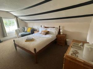 1 dormitorio con 1 cama y 1 silla en Number 2 at The Red Lion, en Huntley