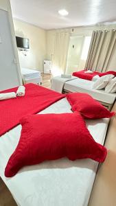 um quarto com 2 camas com almofadas vermelhas em Pousada Helena em Penha