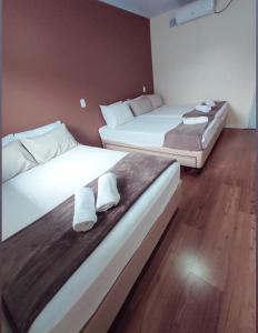 duas camas num quarto de hotel com toalhas brancas em Pousada Helena em Penha