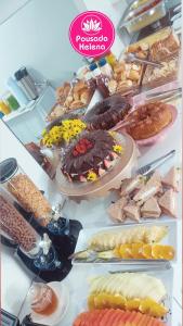 una mesa llena de muchos tipos de alimentos diferentes en Pousada Helena, en Penha