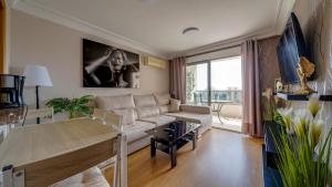 a living room with a couch and a table at Apartamento de 1 dormitorio La Cala Villa Joyosa in Villajoyosa