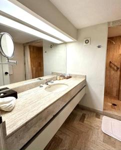 a bathroom with a sink and a large mirror at Departamento Frente a la Playa, Velas Vallarta in Puerto Vallarta