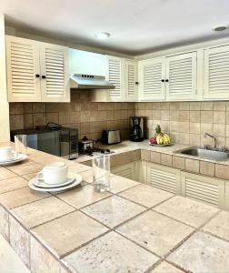 une cuisine avec des placards blancs et un comptoir dans l'établissement Departamento Frente a la Playa, Velas Vallarta, à Puerto Vallarta
