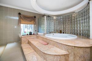 baño grande con bañera y ventana en Villa Amor, en Pretoria