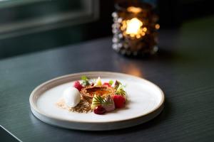 a plate of food with strawberries and whipped cream at Scandic Laholmen in Strömstad +28 photos