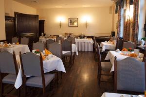 ein Esszimmer mit Tischen und weißen Tischdecken in der Unterkunft Hotel & Restaurant Klosterhof in Dresden