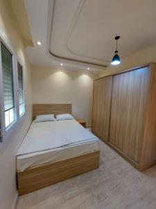 um quarto com uma cama grande e um armário de madeira em شقه فندقية رائعة في مركز مدينة الإسكندرية em Alexandria