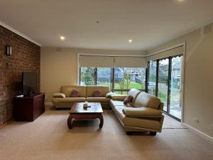 a living room with two couches and a coffee table at Central Sunbury home with top hill views, high speed Wifi, Netflix & Prime Video in Sunbury