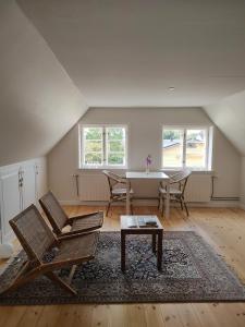 een zolderwoonkamer met een tafel en stoelen bij Købmandsgården in Ballen