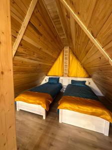 two beds in a room with a attic at La Poalele Vulcanilor in Densuş