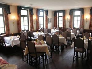 a dining room with white tables and chairs and windows at Hotel & Restaurant Klosterhof in Dresden