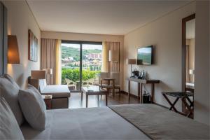 a hotel room with a bed and a living room at Vila Gale Collection Douro in Lamego