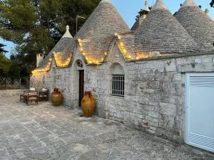 an old stone building with lights on it at Trullo Ronzicchio in Cisternino